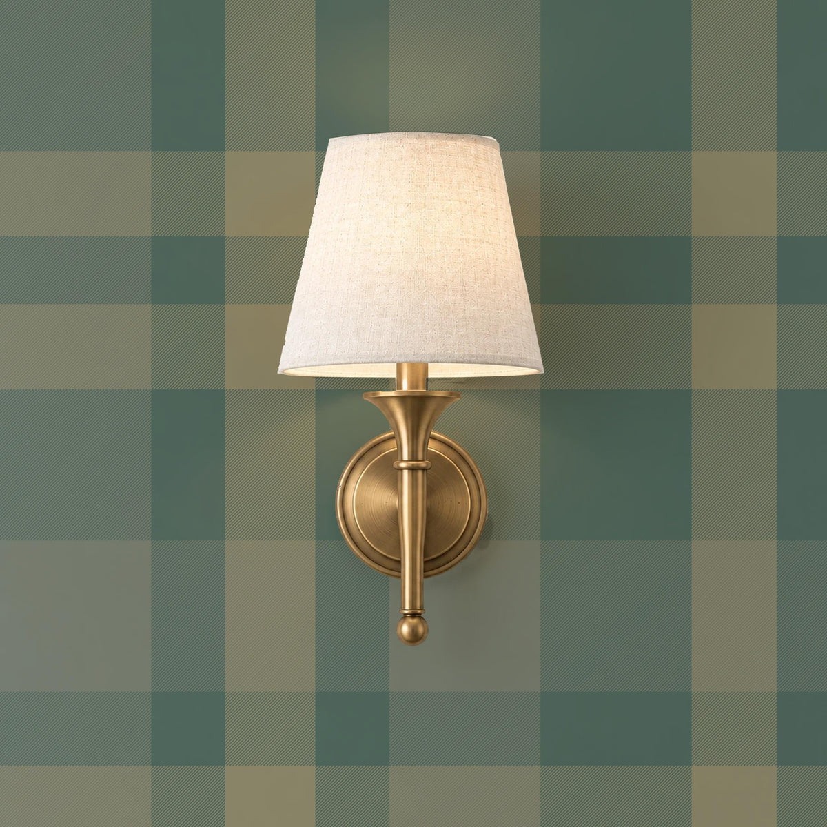 Forest green tartan wallpaper with a brass sconce in a lodge style room