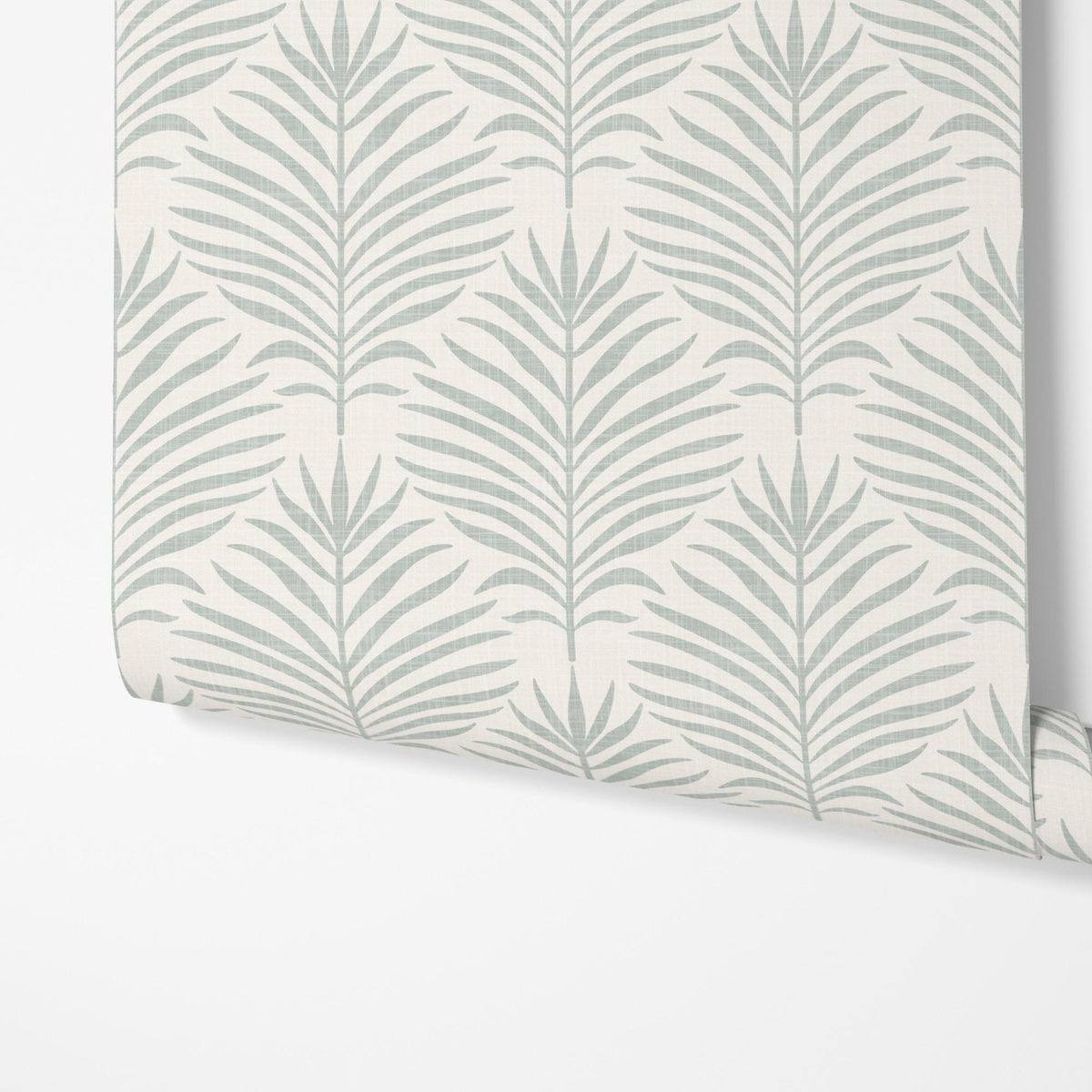 A panel of gray green and white Palm Breeze palm leaf wallpaper being hung on a wall