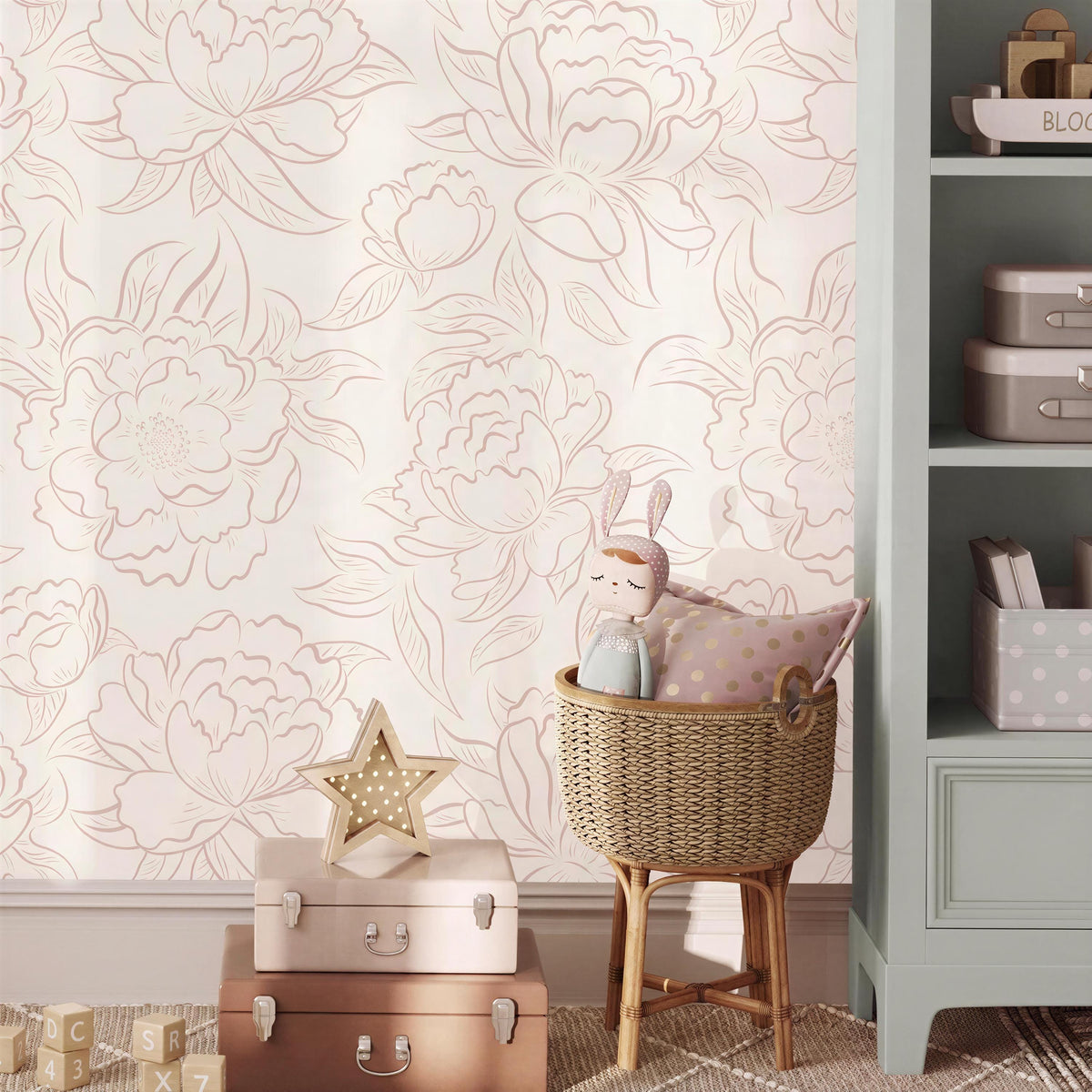 Nursery corner with a bookshelf and toy basket against pink Peony Sketch floral wallpaper