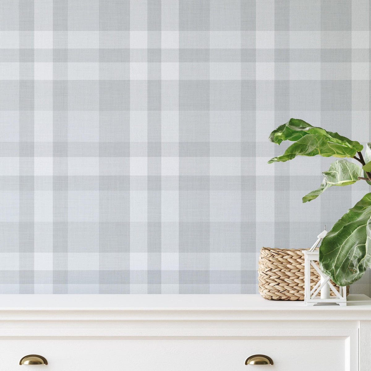 White sideboard with a basket and potted plant against Hollis Plaid wallpaper in blue gray and white