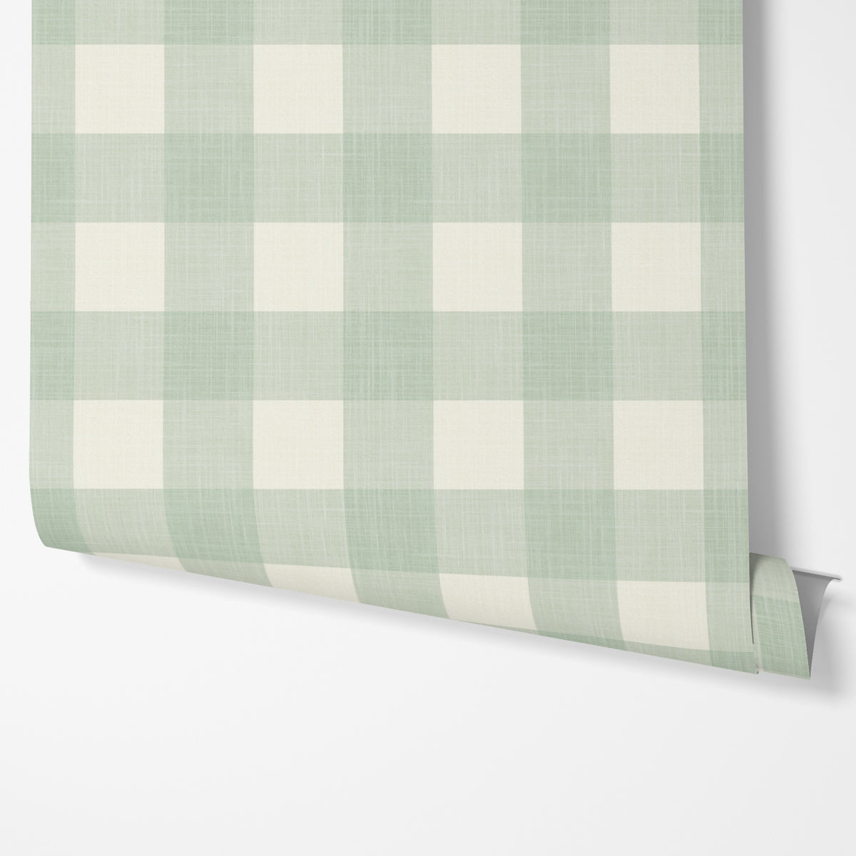 Panel of sage green gingham peel and stick wallpaper hung on a wall
