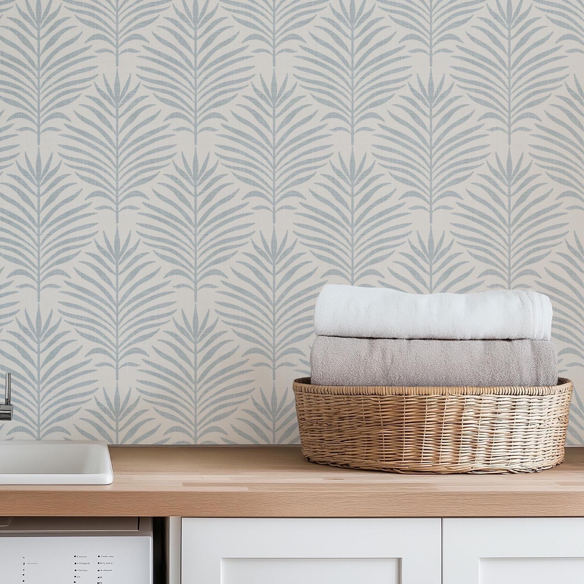 blue palms on off white removable wallpaper with a delicate faux linen texture featured as an accent wall in a laundry room