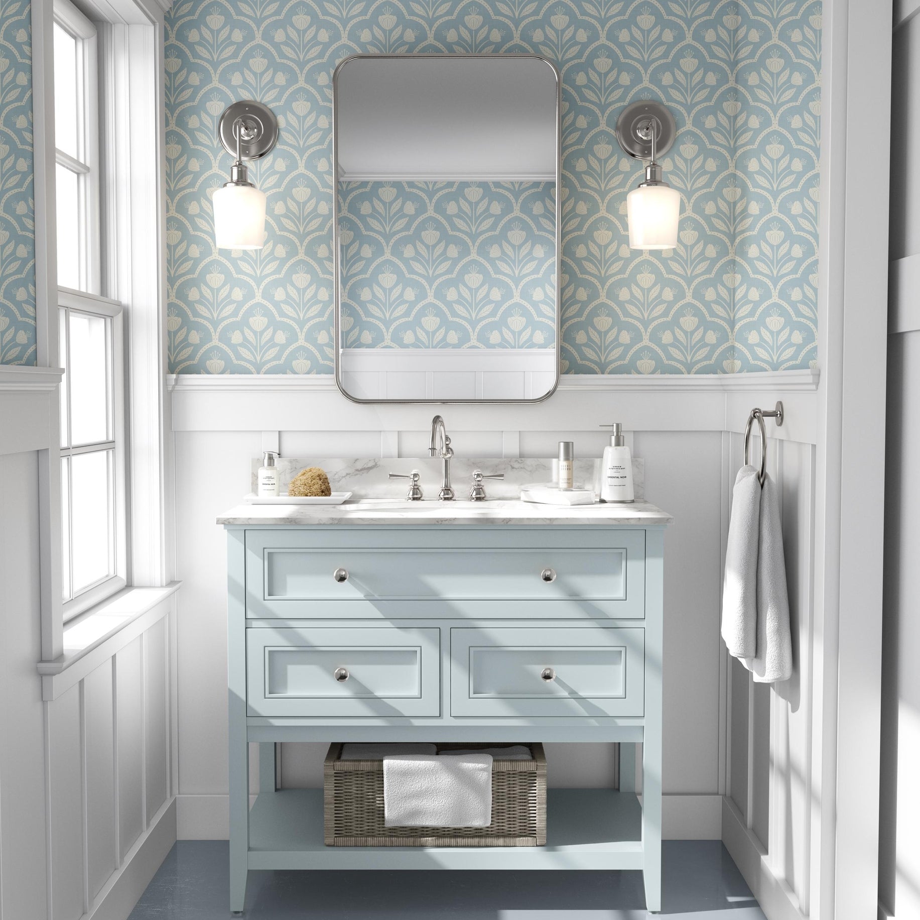 Wallpaper Removable in peel and stick or Pre-Pasted. A light blue pastel Cottagecore Wildflower Floral for Baby Nursery, Bathroom, Laundry Room Accent wall. Features a repeating medallion print with flowers inside for a vintage or tiled appearance. Featured in in airy white bathroom as an accent wall.