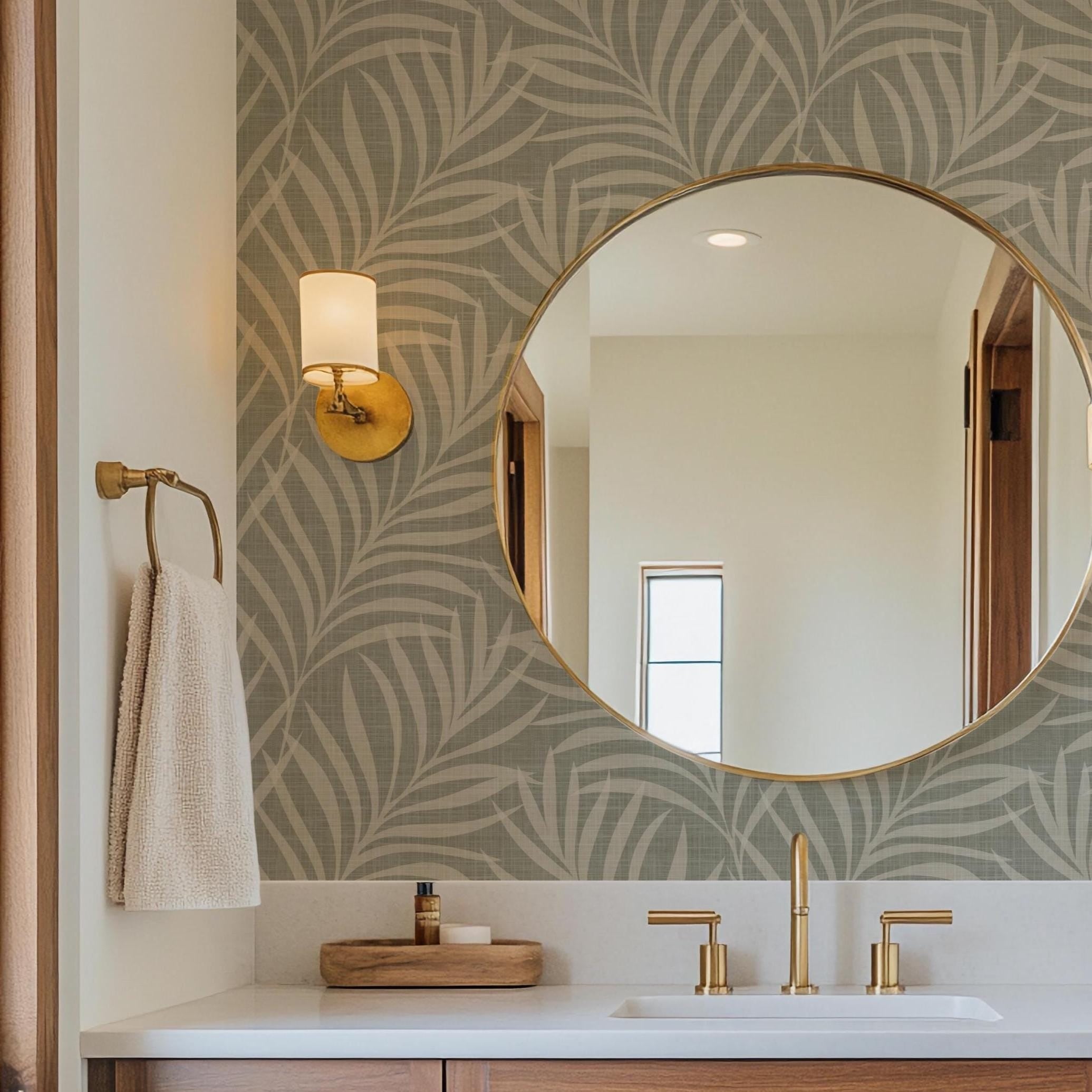 Neutral olive green wallpaper available in peel and stick and prepasted in a modern tropical boho style with palm leaves and subtle linen texture, ideal for coastal bedrooms, powder rooms, or Japandi accent walls. featured as bathroom accent wall.