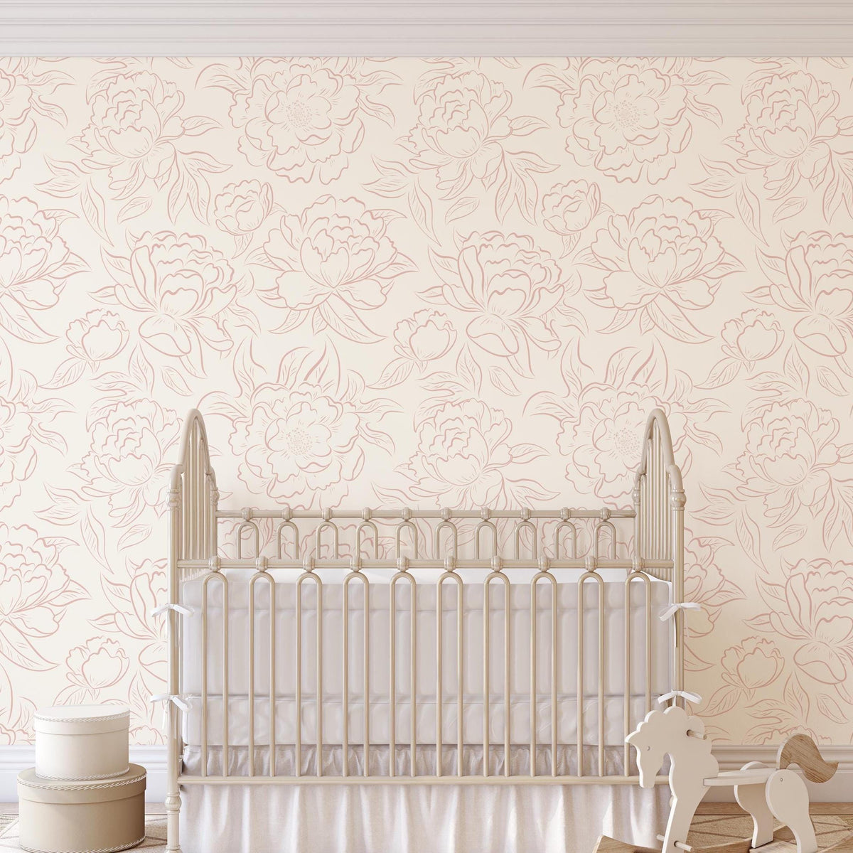 Nursery with a white crib against blush pink Peony Sketch floral wallpaper
