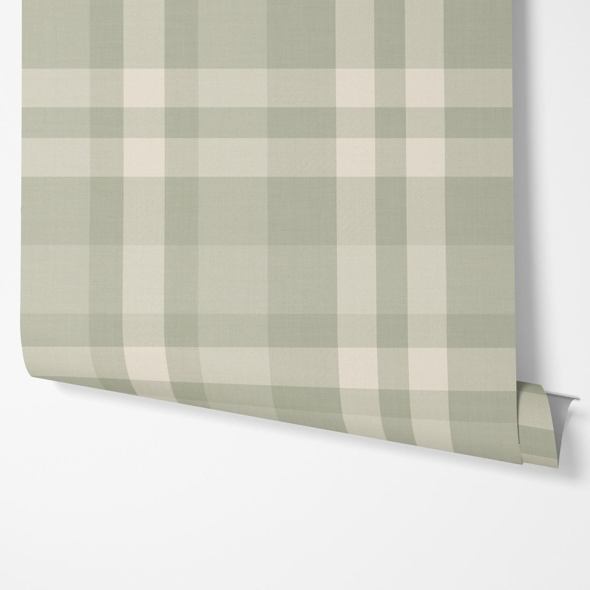 Panel of sage green plaid peel and stick wallpaper hung on a wall