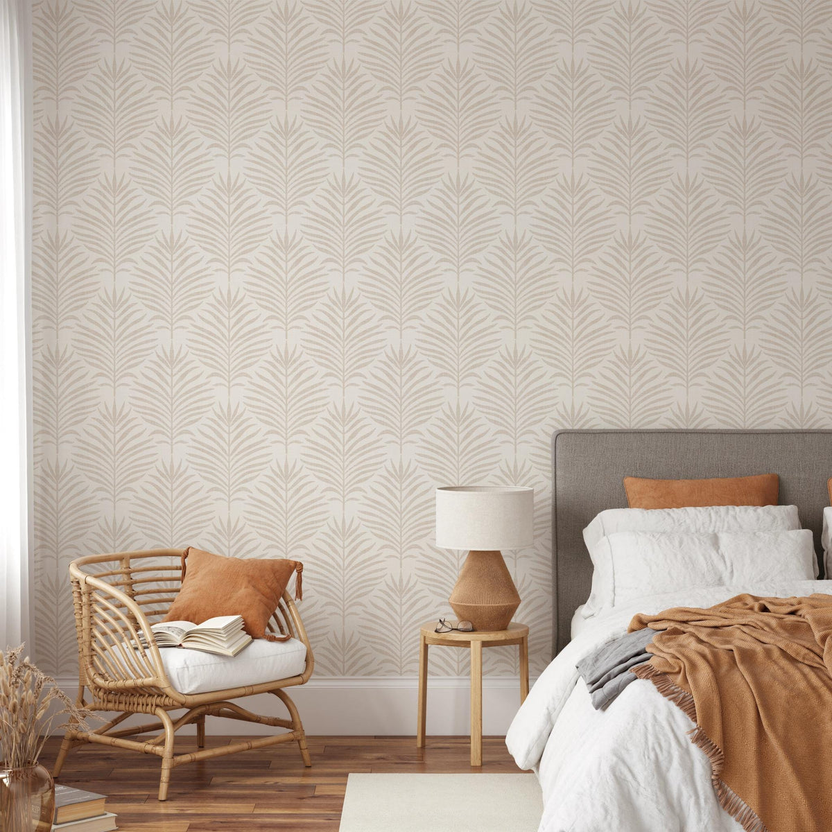 Bedroom with a rattan chair and bed against beige and white Palm Breeze palm leaf wallpaper