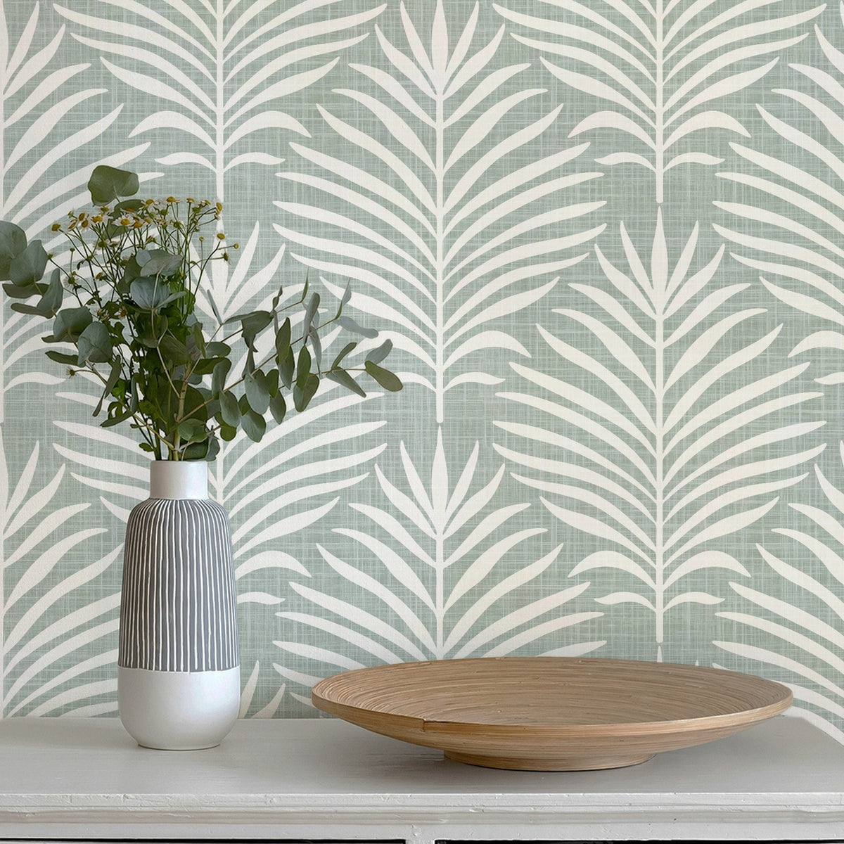 tropical palm leaf wallpaper in green and white shown in peel and stick, prepasted or traditional nonpasted for beach house or modern coastal aesthetic.