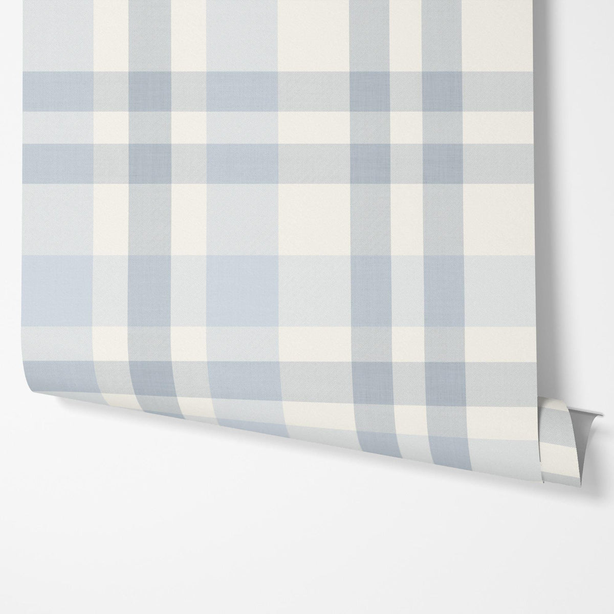 Panel of light blue plaid peel and stick wallpaper hung on a wall