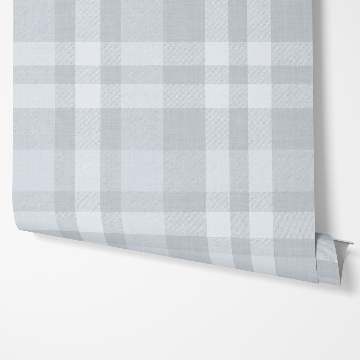 Panel of dusty blue plaid peel and stick wallpaper hung on a wall