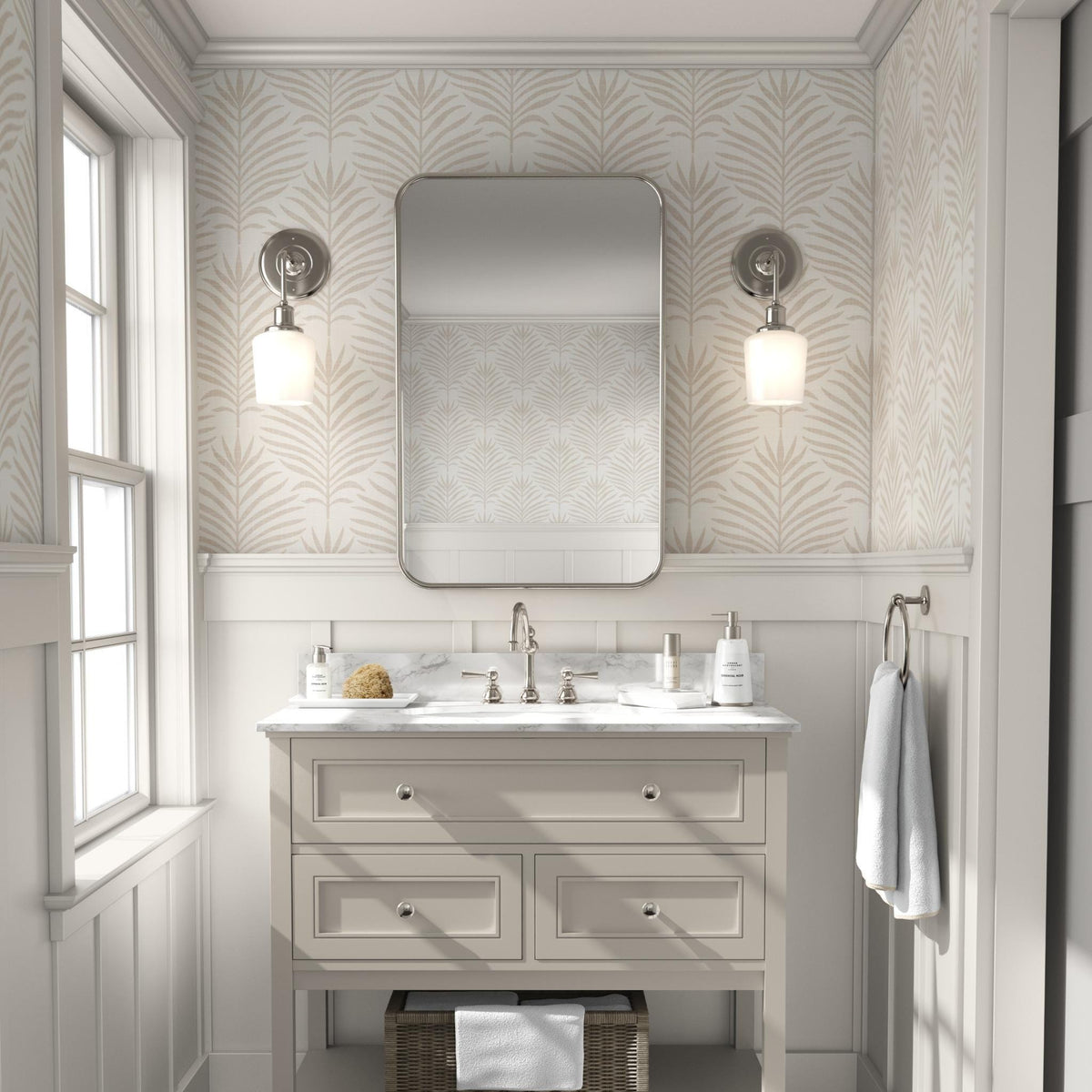 Bathroom vanity with a mirror and sconces on a wall of beige and white Palm Breeze palm leaf wallpaper