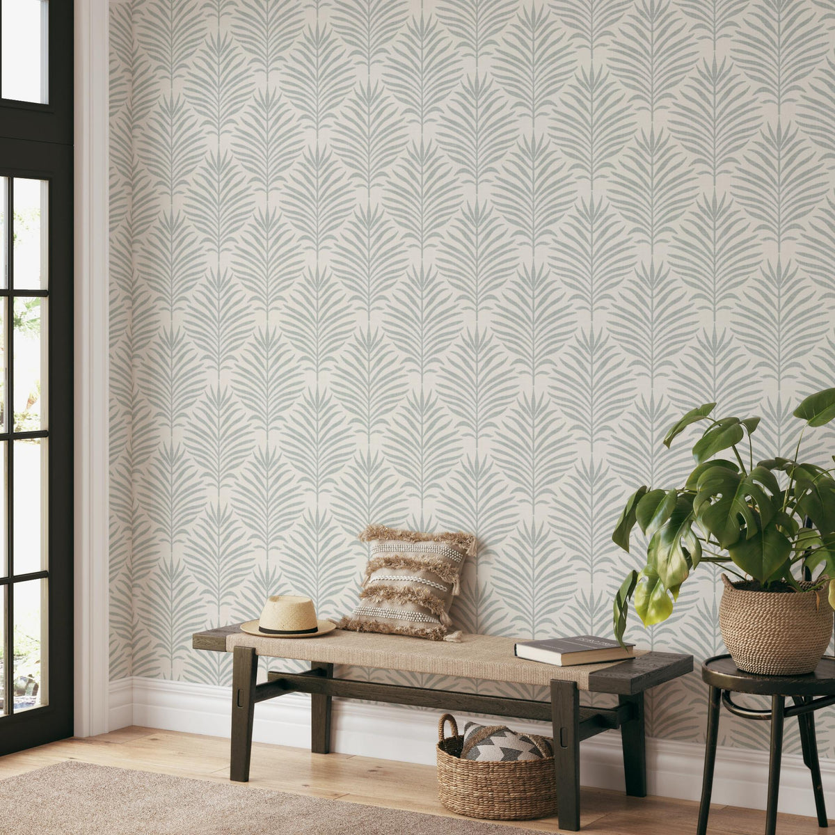 Entryway with a bench and potted plant against gray green and white Palm Breeze palm leaf wallpaper