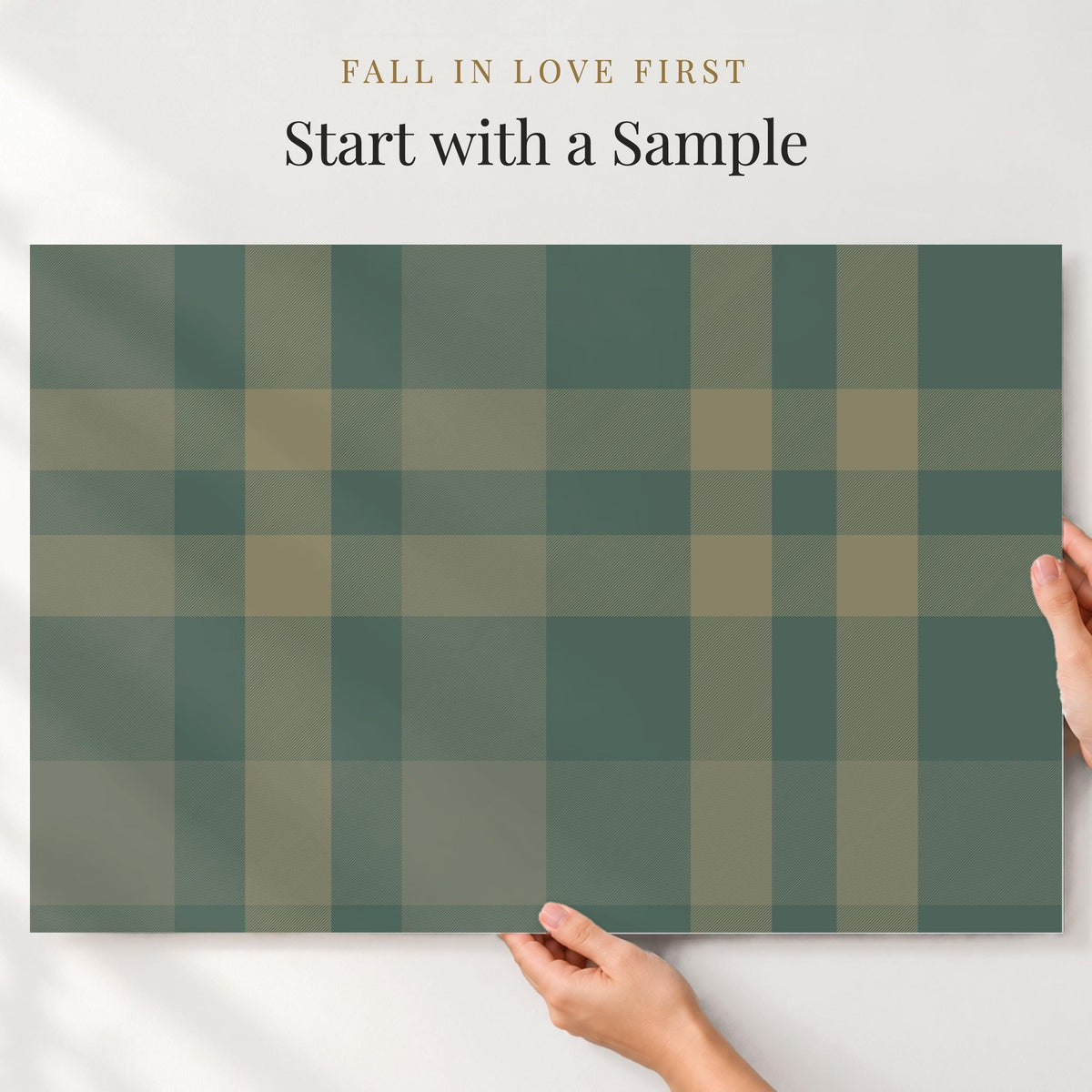 Large sample of forest green plaid wallpaper held up to the wall