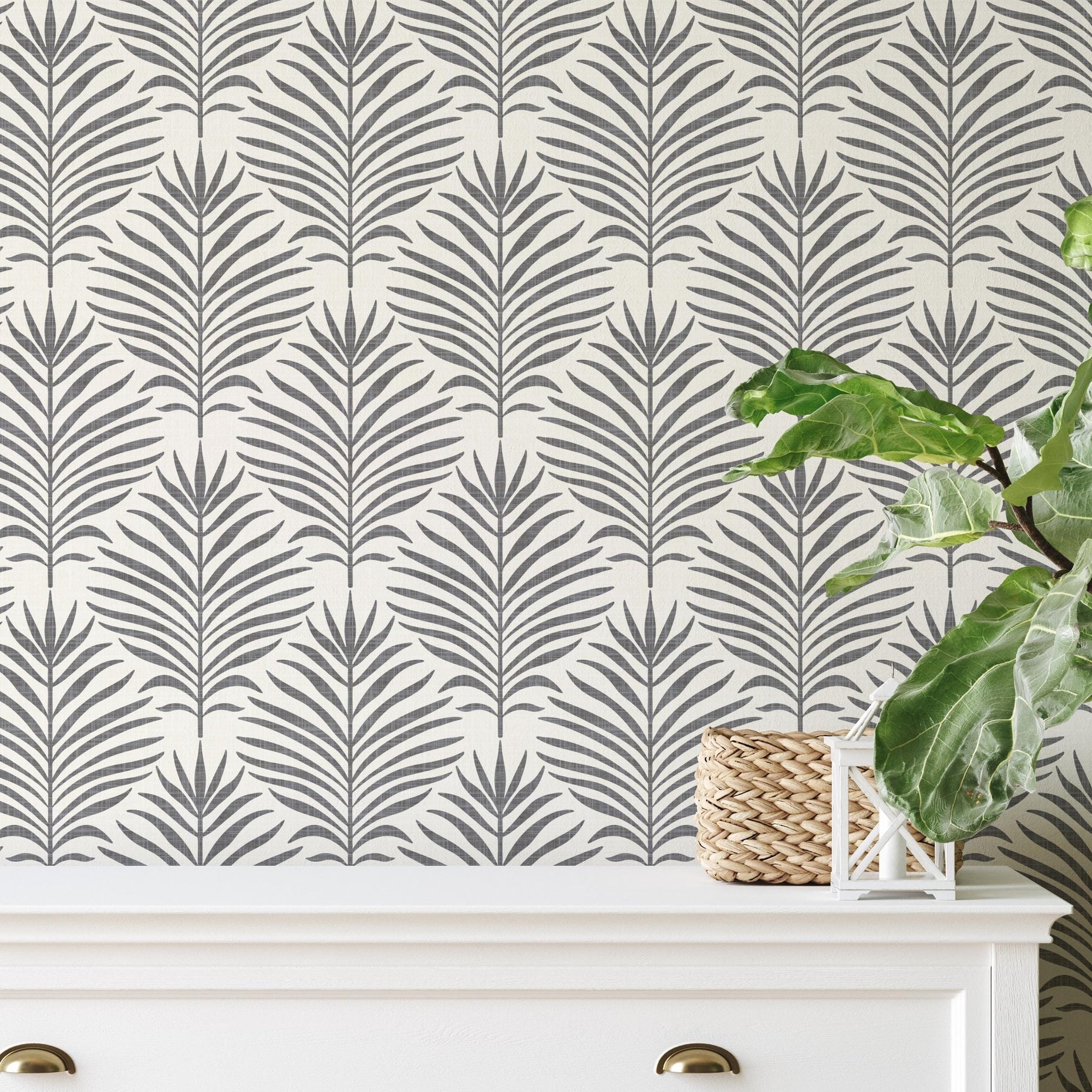 Neutral charcoal black and white palm leaf wallpaper available in peel and stick and prepasted in a modern tropical boho style with a subtle linen texture, ideal for coastal bedrooms, powder rooms, or modern accent walls. featured as living rooms statement wall