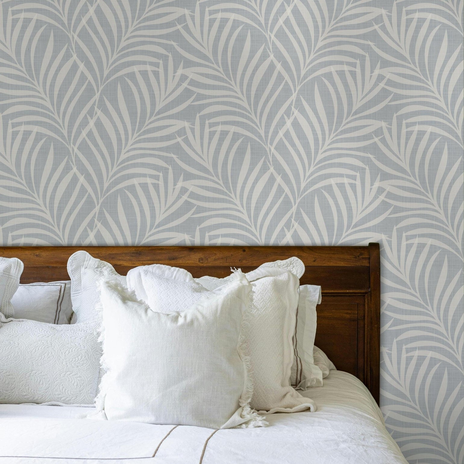 tropical boho palm leaf wallpaper in soft calm blue and white shown in removable peel and stick or prepasted. Perfect for modern coastal bathroom, powder room, nursery or laundry room accent wall.